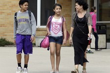  - 
              In this April 10, 2013 photo Heather Coffy, right, walks out of St. Monica's School at  the end of the school day with her children Darius Coffy, 13, left, and Alanna Marshall, two of h