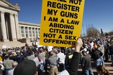  - 
              Lance Gentry of Chouteau, Okla.,  holds one of three signs he brought to the rally, Saturday, Jan. 19, 2013 in Oklahoma City. Organizers said an estimated 1800 people from throughout Ok