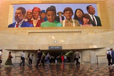  - 
              FILE - In this Aug. 30 2000, file photo, commuters walk into a tunnel at Los Angeles's  Amtrack-Metrolink Union Station under the mural "City of Dreams/River of History" by artist Richa
