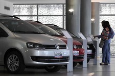  - 
              In this Feb. 1, 2013 photo, a couple looks at the price of a new vehicle that has already been sold, parked next to other already sold cars on display at a Volkswagen salesroom in Carac