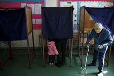  - 
              A woman, right, leaves a polling booth as a mother with her child votes in an other booth in the Presidential election in southern port city of Limassol, Cyprus, Sunday, Feb. 17, 2013. 
