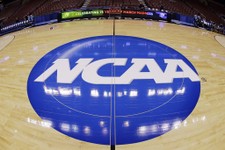  - 
              FILE - In this March 21, 2013, file photo, in this image taken with a fisheye lens, the NCAA logo is displayed at mid-court before Albany's practice for a second-round game of the NCAA 
