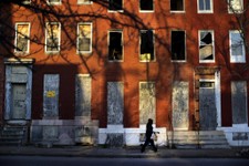  - 
              In this March 30, 2013 picture, a woman walks past blighted row houses in Baltimore. Baltimore is far from the worst American city for poverty, but it faces all the problems of cities w