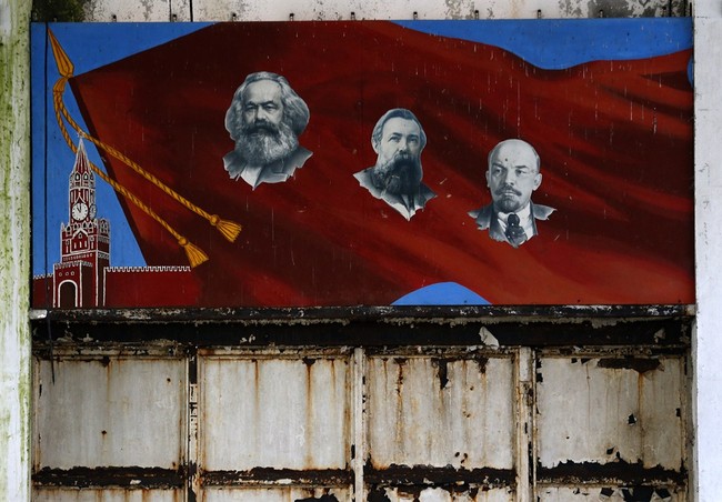 In this photo taken Friday, Nov. 7, 2014 a mural depicting Communist leaders, from left, Karl Marx, Friedrich Engels and Vladimir Lenin hangs on a wall of a bomb assembly and repair fac