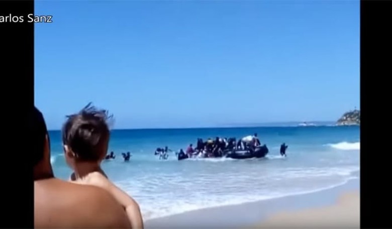 Migrants Storm Beach in Southern Spain as Confused Sunbathers Look On