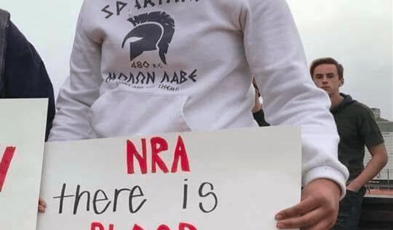 Anti-Gun Protester Holds Anti-NRA Sign With Pro-Gun Motto on Her Hoodie