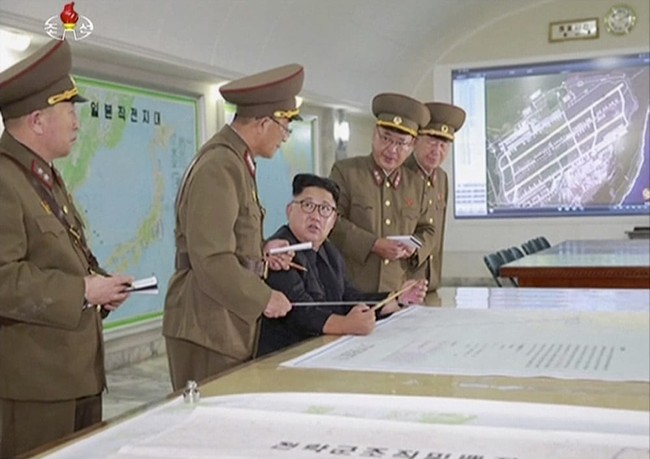 This image made from video of an Aug. 14, 2017, still image broadcast in a news bulletin on Tuesday, Aug. 15, 2017, by North Korea's KRT shows North Korean leader Kim Jong Un receiving a briefing in Pyongyang. North Korea said leader Kim Jong Un was briefed on his military's plans to launch missiles in waters near Guam days after the Korean People's Army announced its preparing to create "enveloping fire" near the U.S. military hub in the Pacific. Independent journalists were not given access to cover the event depicted in this photo. (KRT via AP Video)
