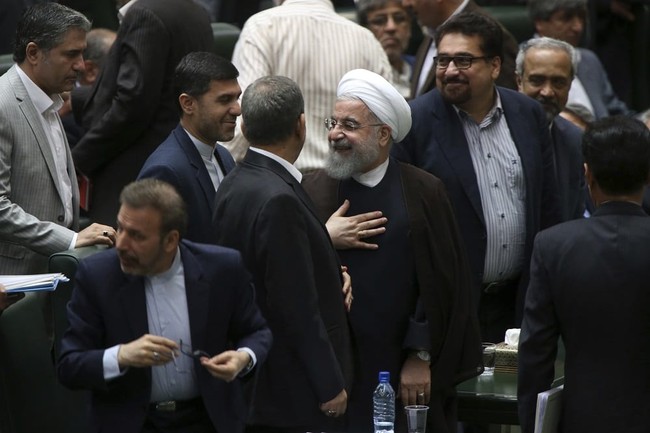 Iranian President Hassan Rouhani, center, leaves the parliament after his speech in a session to debate his proposed cabinet, in Tehran, Iran, Tuesday, Aug. 15, 2017. Iran's president issued a direct threat to the West on Tuesday, claiming his country is capable of restarting its nuclear program within hours — and quickly bringing it to even more advanced levels than in 2015, when Iran signed the nuclear deal with world powers. (AP Photo/Vahid Salemi)