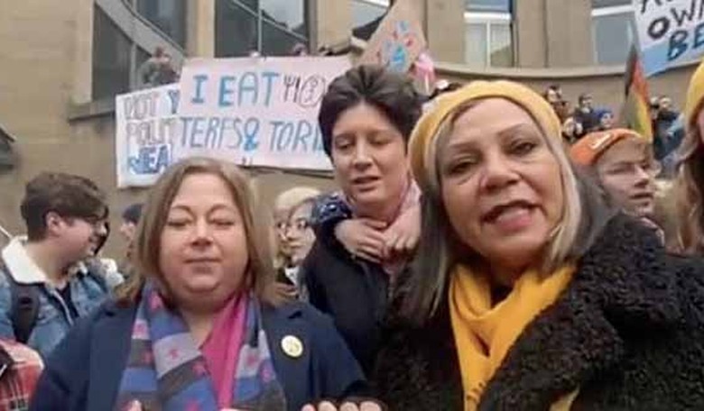 J.K. Rowling shows off some Scottish politicians in front of banners reading, 'Decapitate TERFs'
