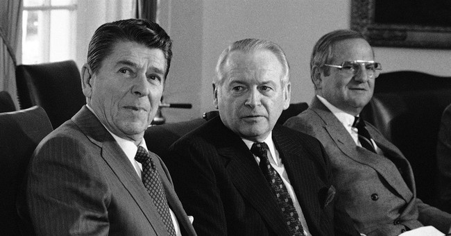 FILE - In this Dec 19, 1981, file photo, U.S. President Ronald Reagan, left, meets with auto industry executives, including Ford President Philip Caldwell, center, and Chrysler President Lee Iacocca at a luncheon in the White House Cabinet room, Washington. Caldwell was the first CEO of Ford who wasn’t a member of the Ford Family. Ford named Jim Hackett its 10th CEO Monday, May 22, 2017. (AP Photo/Dennis Cook, File) 