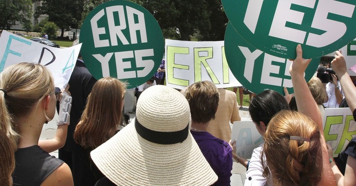 FILE - In this June 22, 2011 file photo, women hold up signs on Capitol Hill in Washington during a news conference in support of the re-introduction of the Equal Rights Amendment. The