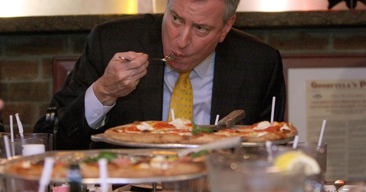 FILE- In this Jan. 10, 2014 file photo, New York City Mayor Bill de Blasio eats pizza with a fork at Goodfellas Pizza in the Staten Island borough of New York. A charity auction website