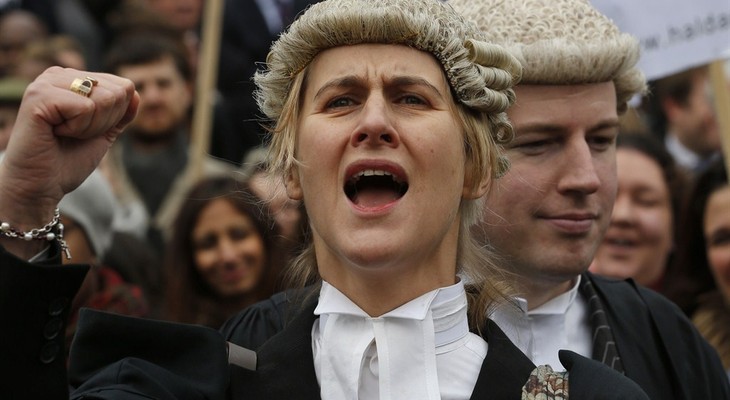 Barrister Juliet Donovan in her full court dress of wig and gown, chants slogans during a rally to protest against legal aid cuts, across from the Houses of Parliament in central London