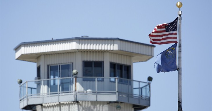 Flags fly near a guard tower at High Desert State Prison Wednesday, April 15, 2015, in Indian Springs, Nev. Recent disclosures that a Nevada prison inmate was shot dead by a prison guar