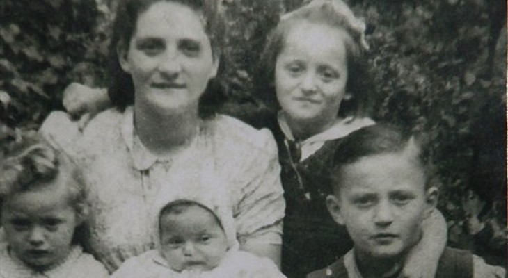 This photograph, taken in 1947 in Dzierzoniow, Poland, shows Moshe Tirosh as a boy with his mother and siblings. Tirosh incredibly survived the Holocaust, being thrown out of the Warsaw