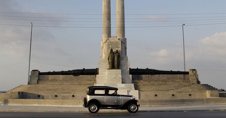 FILE - In this Feb. 12, 2013 file photo, a person drives a vintage automobile past the restored USS Maine monument in Havana, Cuba. The battleship USS Maine was destroyed in an explosio