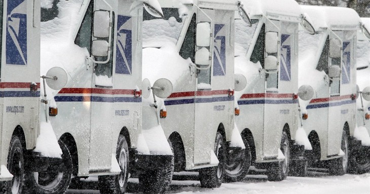 Snow-covered U.S. Postal Service vehicles sit idle, Monday, Feb. 9, 2015, in Marlborough, Mass. New England and portions of New York state awoke Monday to a fresh blanket of snow as a s