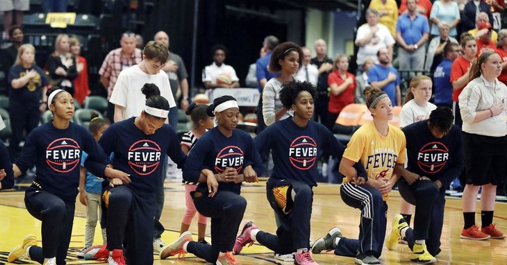 Members of the Indiana Fever kneel during the playing of the national anthem before the start of of a first round WNBA playoff basketball game, against the Phoenix Mercury, Wednesday, S