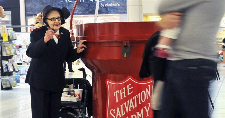 FILE - In this Nov. 15, 2014, file photo, Salvation Army bell ringer Esther Rahenkamp, of Avon Park, Fla., greets shoppers at NorthPark Mall in Davenport, Iowa, standing next to a 700-p